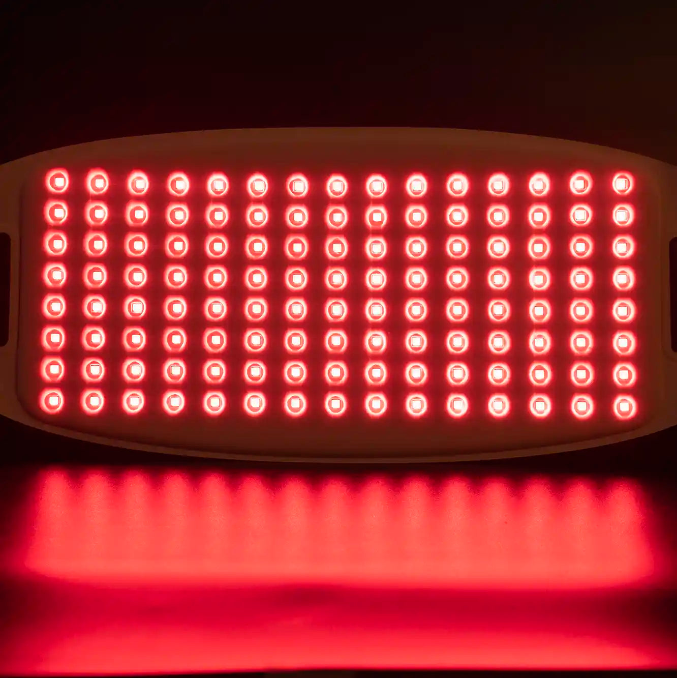 Red light therapy device with multiple LED lights on a dark background